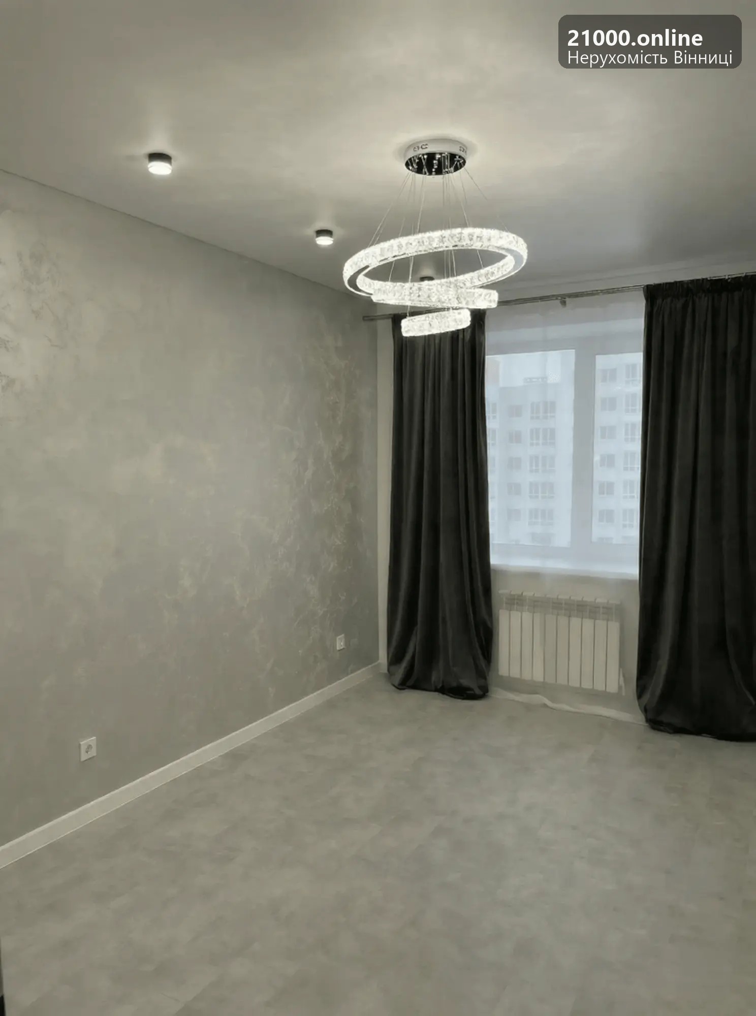 Простора світла кімната з дизайнерською люстрою